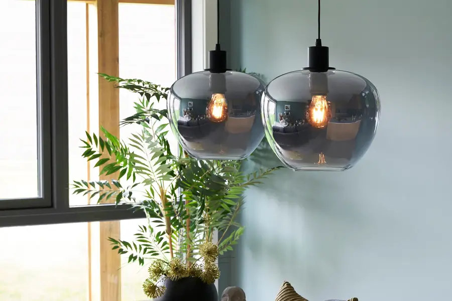 Lampe henger fra taket med maleri i bakgrunn 