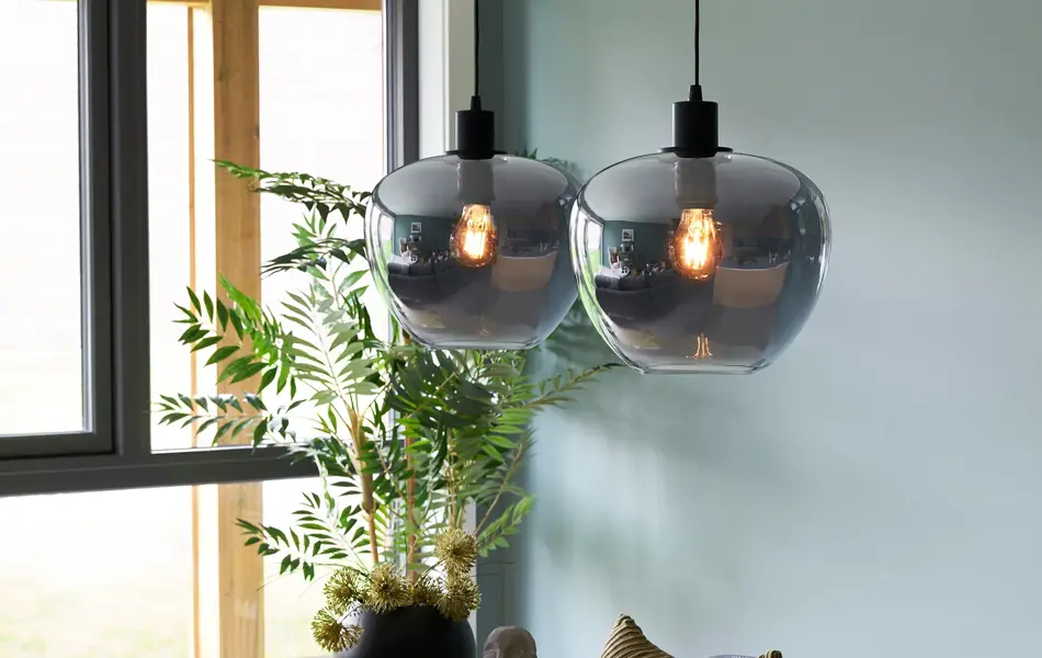 Lampe henger fra taket med maleri i bakgrunn 