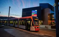 Bilde tatt på kvelden av Bybanen som kjører inn til stoppet ved Lagunen Storsenter.