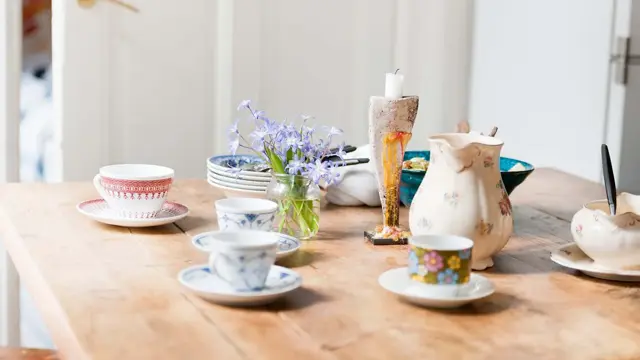 Lilla syriner på hvitt utebord i hagen 