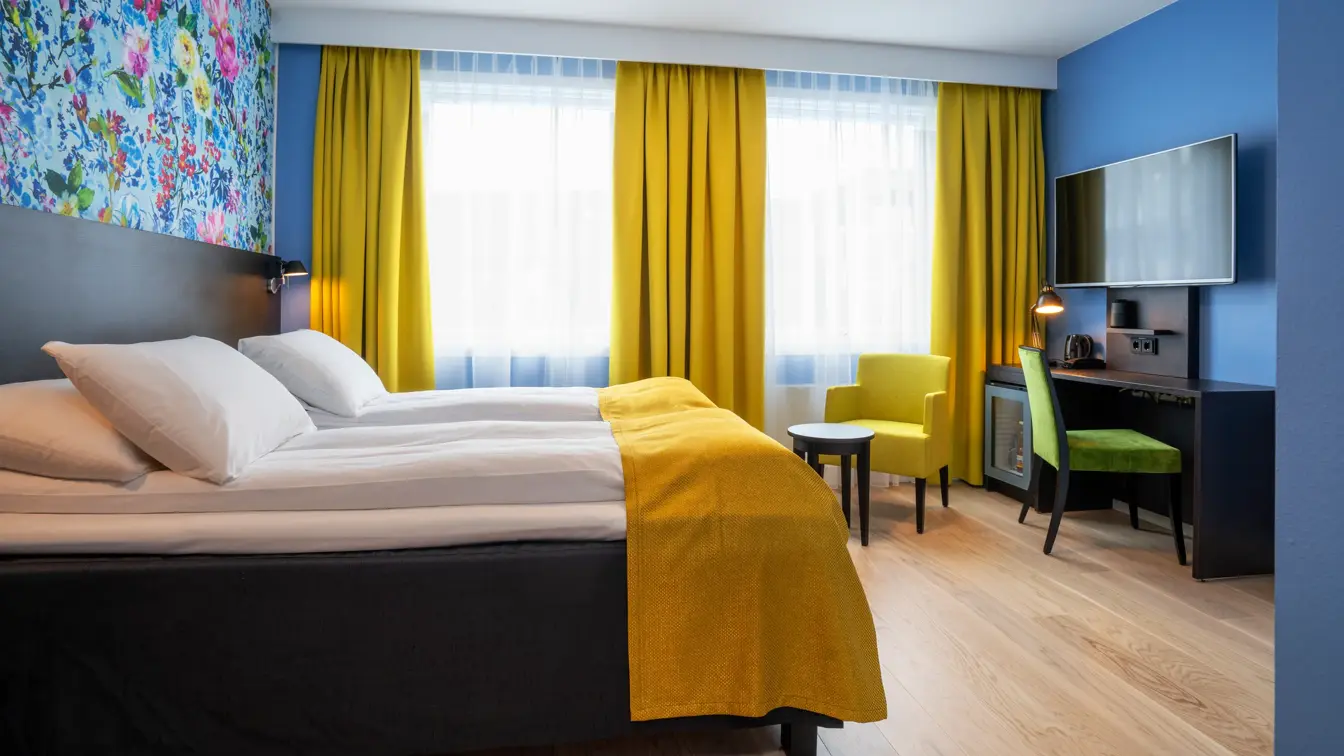 Separate senger, blomstrete tapet, gule gardiner og skrivebord i twin rom på Thon Hotel Moldefjord