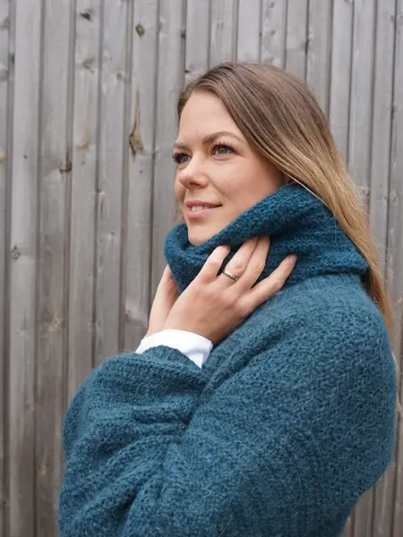 Dame i blå strikket genser og hals