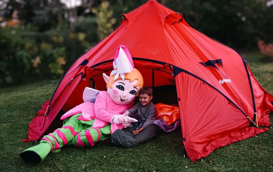 amfelia og gutt koser seg foran rødt telt