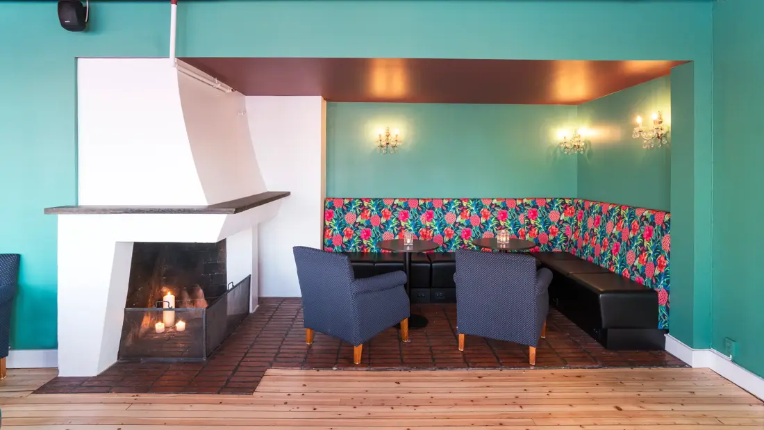 Salongbar medpeis og sottekrok, mønstret tapet over sitteområdet og turkise vegger på Thon Hotel Skeikampen