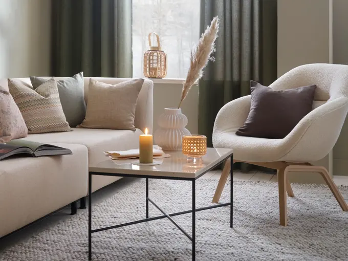 stue med beige sofa og stol og lyse puter