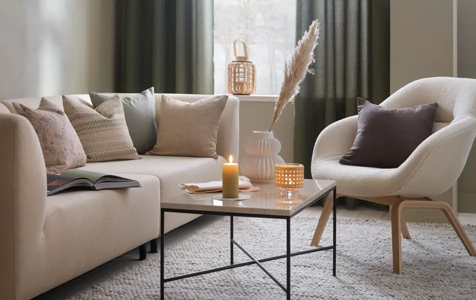 stue med beige sofa og stol og lyse puter