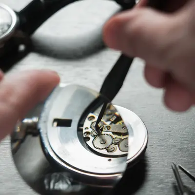 the watchmaker is repairing the old dirty clock