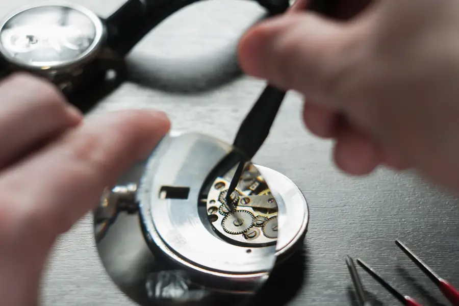 the watchmaker is repairing the old dirty clock
