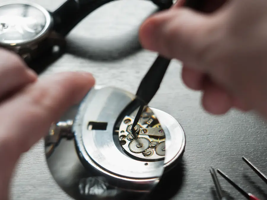 the watchmaker is repairing the old dirty clock