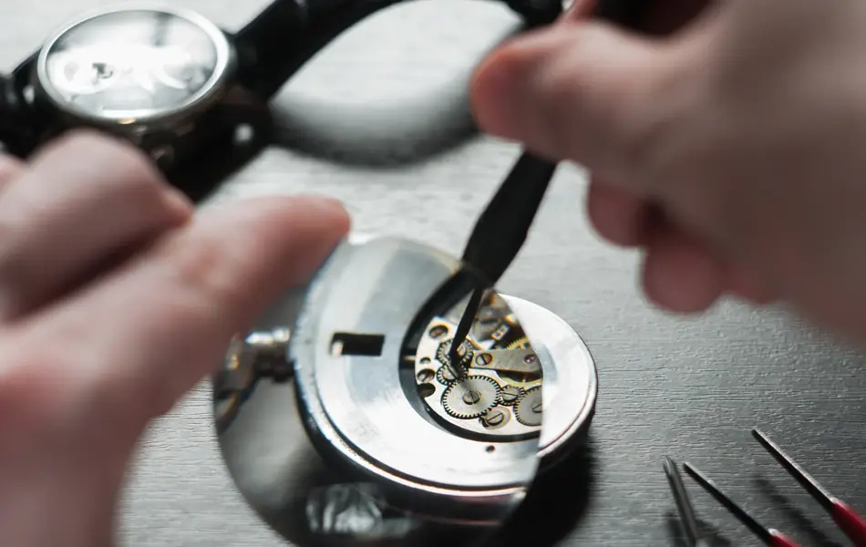 the watchmaker is repairing the old dirty clock