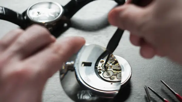 the watchmaker is repairing the old dirty clock