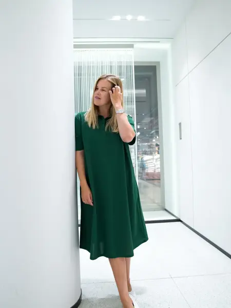 Jente med blondt hår, har på seg en knelang grønn kjole