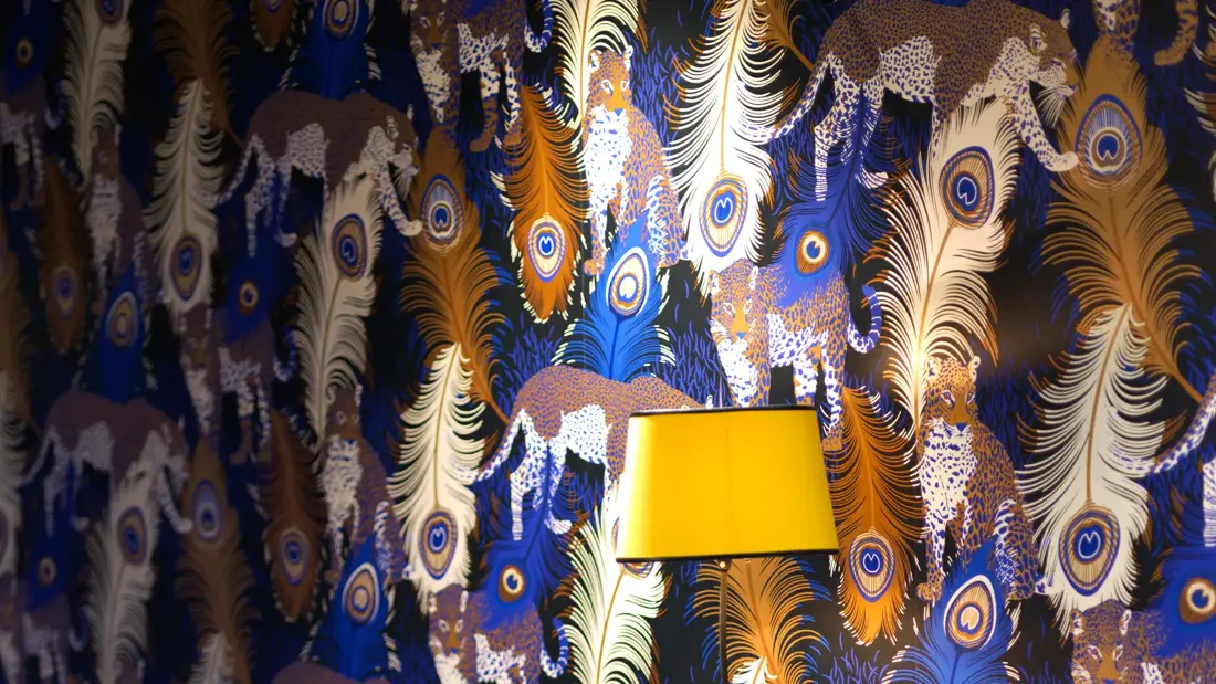 Påfugl-tapet, gul lampe og blå sofa i lounge på Thon Hotel Terminus i Oslo sentrum nær Jernbanetorget