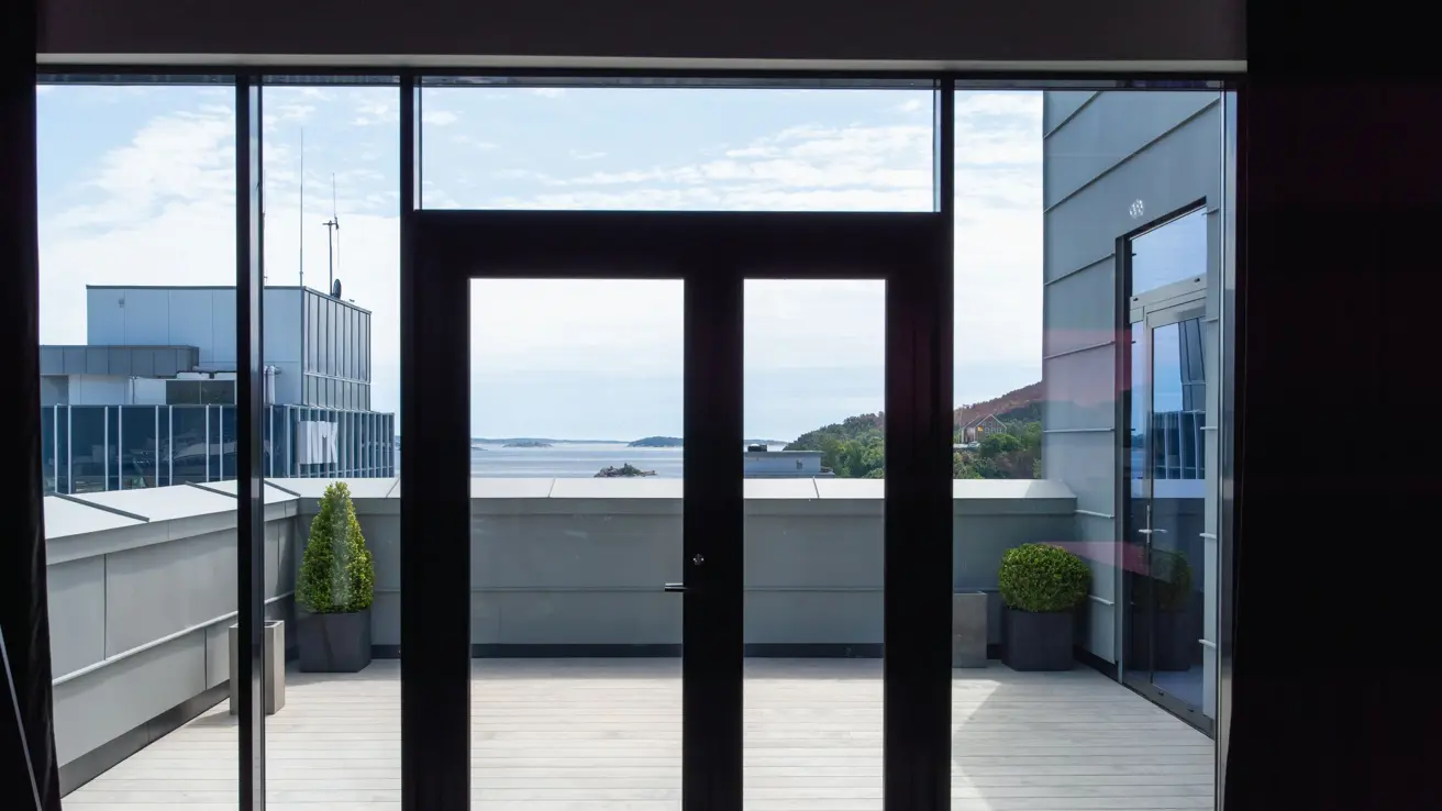 Heldekkende vinduer og dør ut til terrasse med utsikt fra konferansen Stup i 8 etasje.