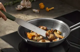 Stekepanne med sopp på en koketopp.