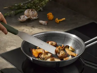 Stekepanne med sopp på en koketopp.
