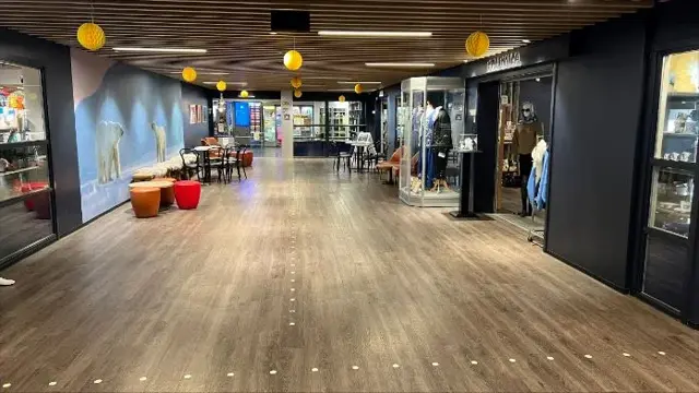 Fellesareal på Lompensenteret, gang med butikker langs sidene.