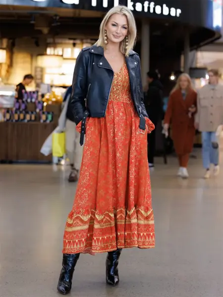 Dame står og smiler med rød kjole