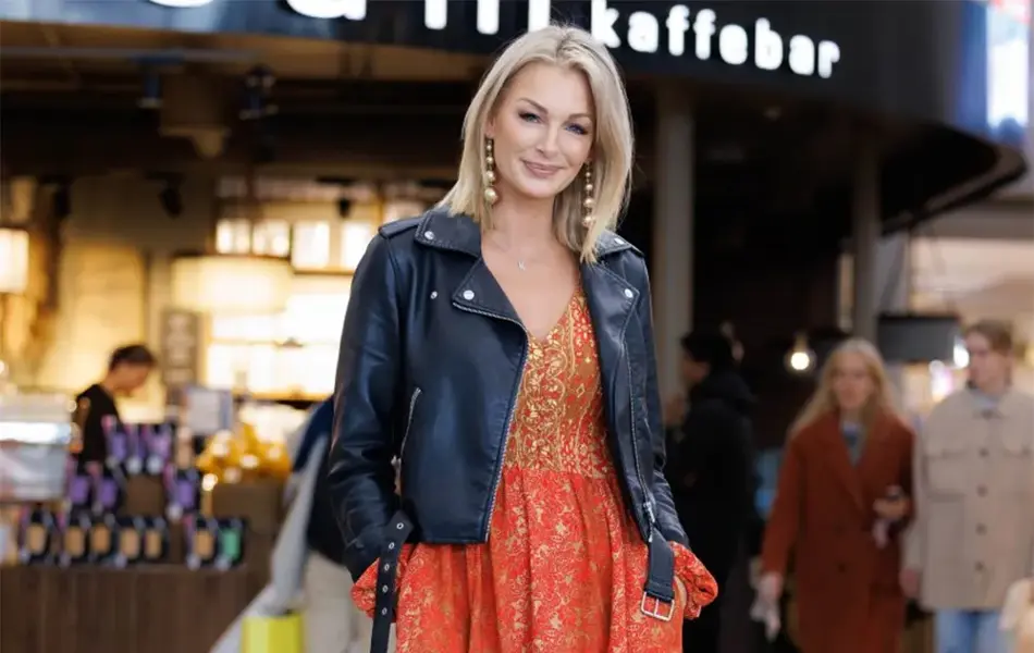 Dame står og smiler med rød kjole