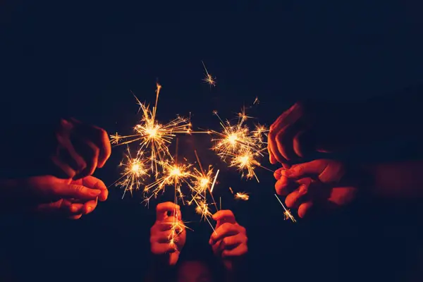 Flere stjerneskudd som lyser opp hendene som holder dem.