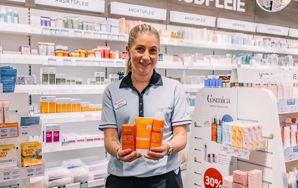 Dame som holder frem solkrem