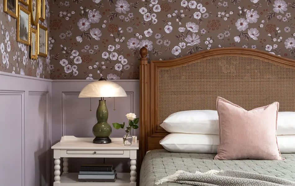 Soverom med seng i mørkt tre, vintage grønn lampe og blomstertapet på veggen 