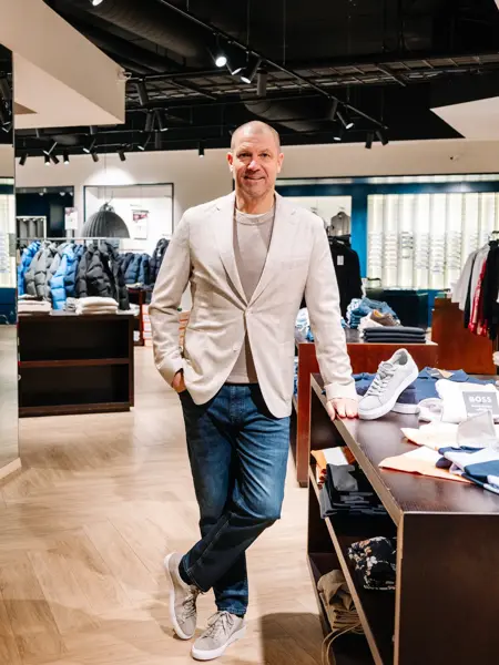 mann i vårklær står i butikk