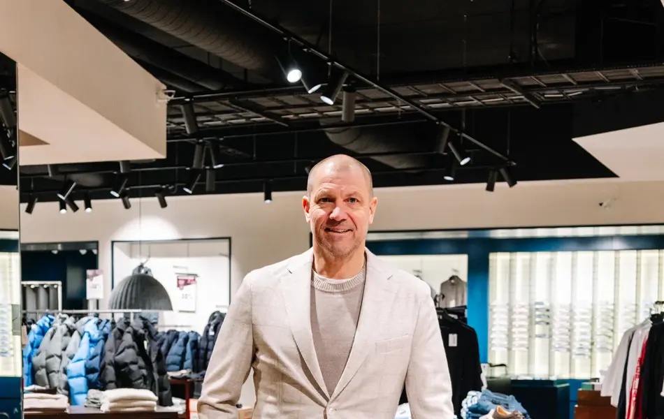mann i vårklær står i butikk