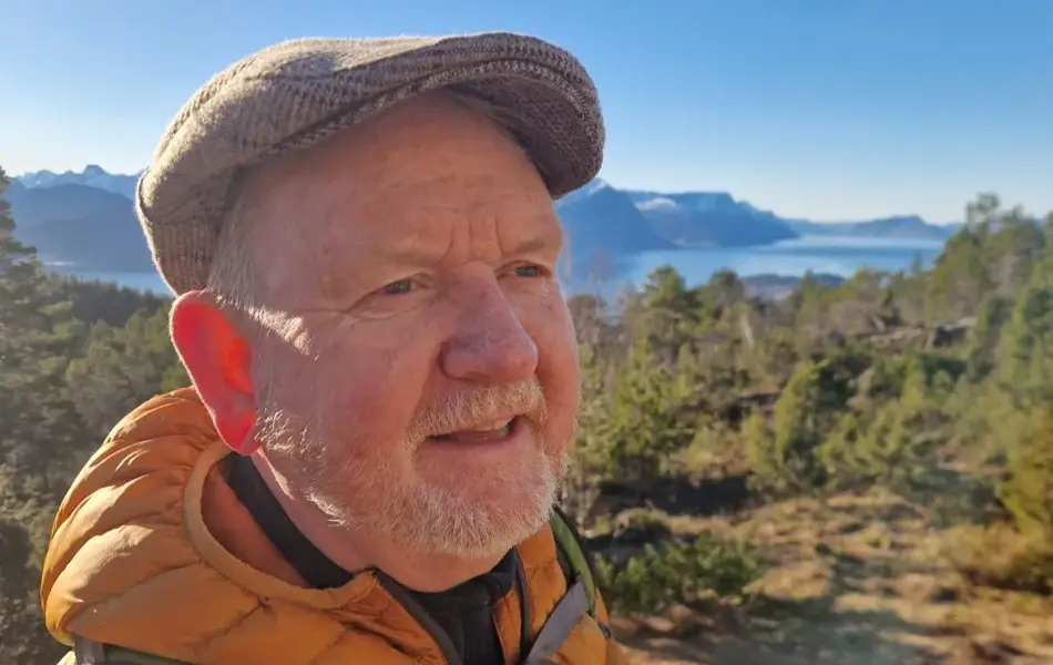 Mann med fjord og fjell i bakgrunnen