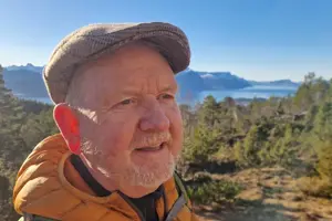 Mann med fjord og fjell i bakgrunnen