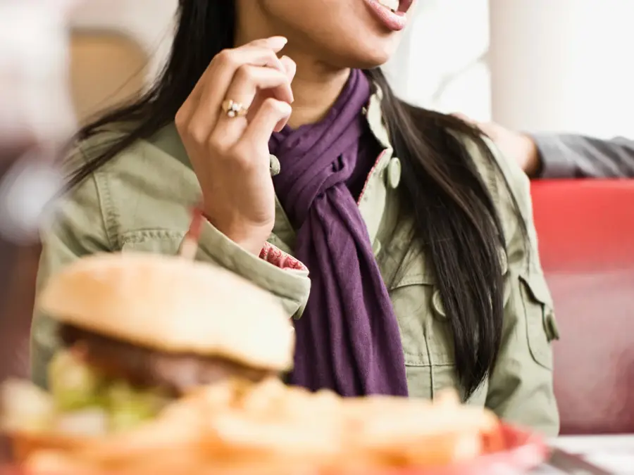 Dame med hamburger og drikke