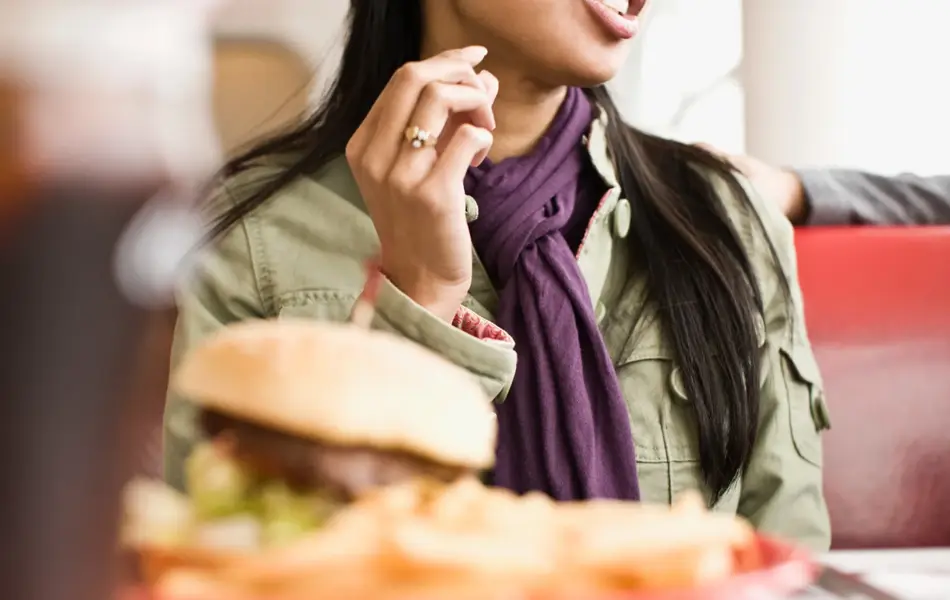 Dame med hamburger og drikke