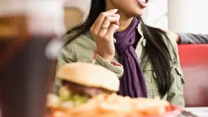 Dame med hamburger og drikke