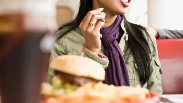 Dame med hamburger og drikke