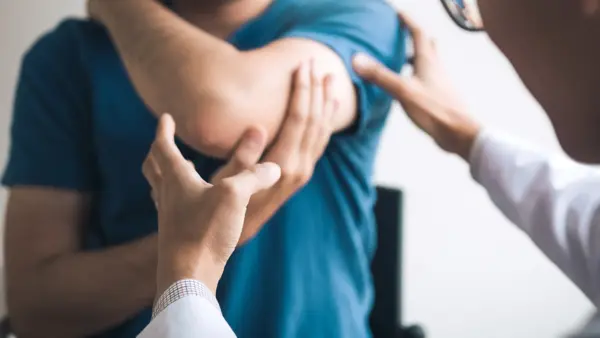 Physical therapists are checking patients elbows at the clinic office room.