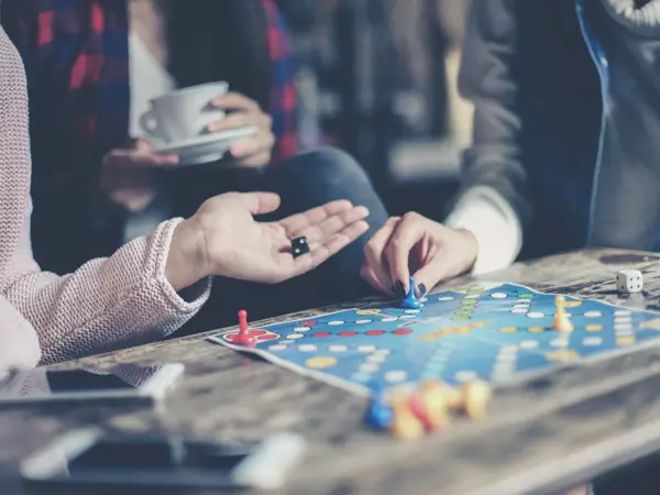 Three girls play together a social game. Focus on hand.