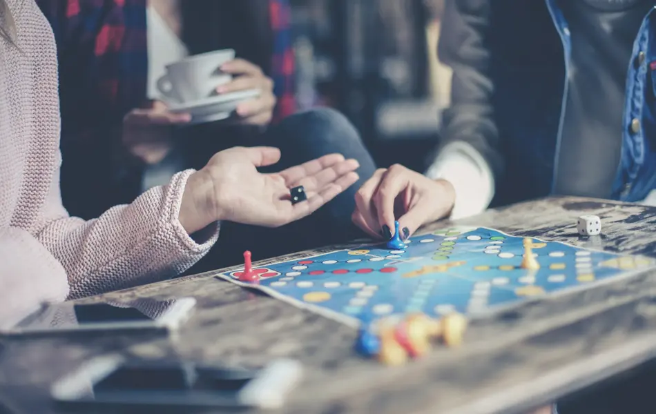 Three girls play together a social game. Focus on hand.