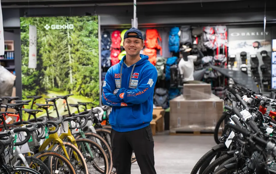 Mann som står og smiler rett i kamera