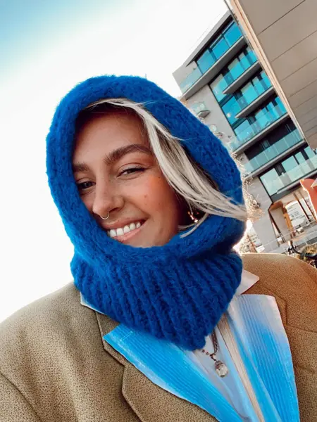 Dame med blå balaklava som smiler