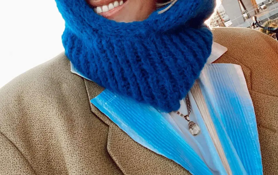 Dame med blå balaklava som smiler