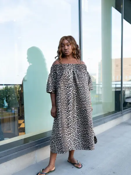 Ung kvinne poserer i lang leopardkjole