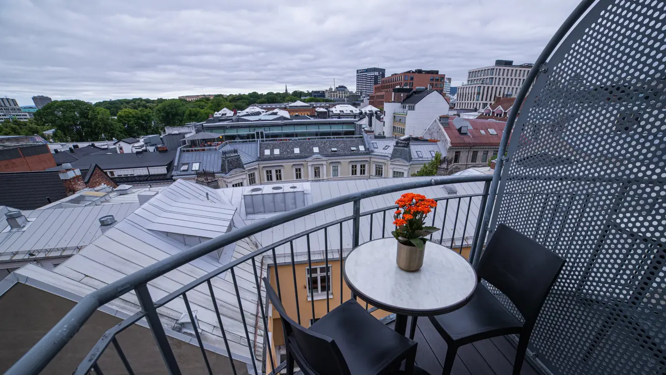Balkong med utsikt, to stoler og lite rundt bord 