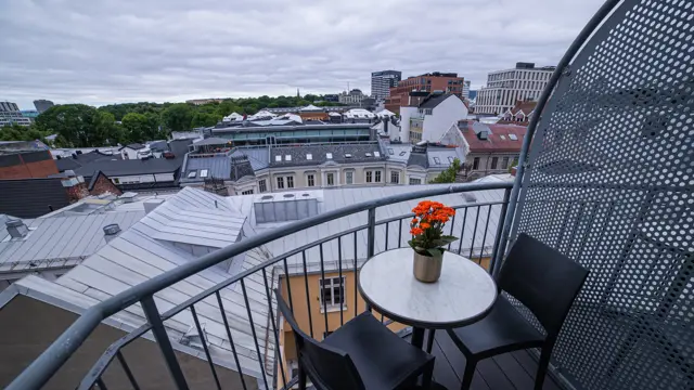 Balkong med utsikt, to stoler og lite rundt bord 