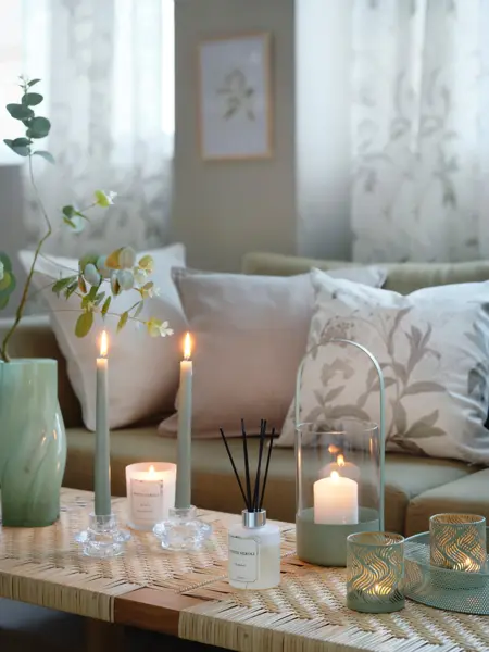 Sofabord med ulike lykter og sofa med pynteputer fra Princess