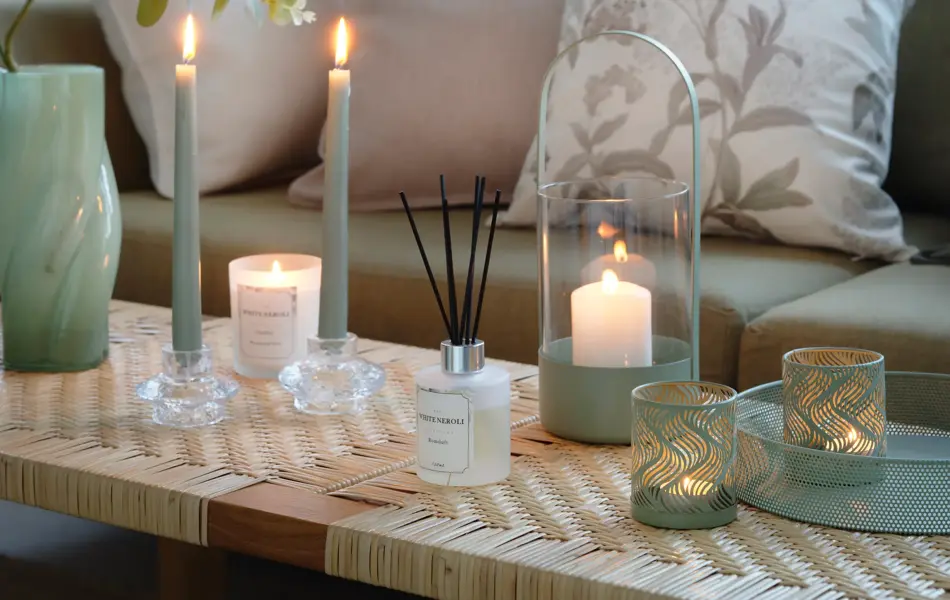 Sofabord med ulike lykter og sofa med pynteputer fra Princess