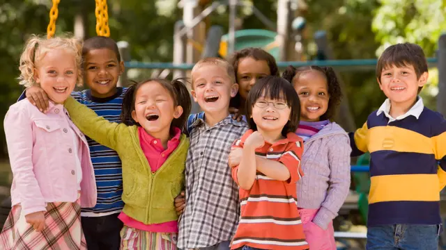 gruppe med barn som smiler og ler på skolen