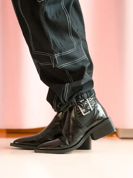 ben med sort bukse og sorte ankelstøvletter