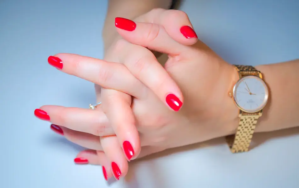 Hender med rød neglelakk