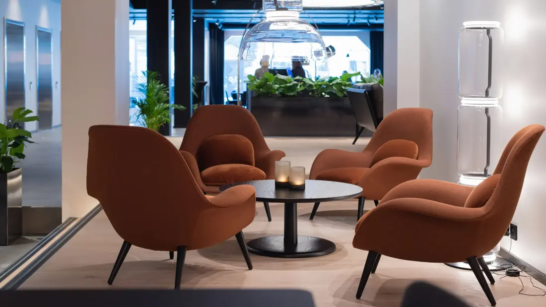 Fire lysebrune stoler rundt sort lavt bord  i lobbyen på Thon Hotel Norge i Kristiansand.