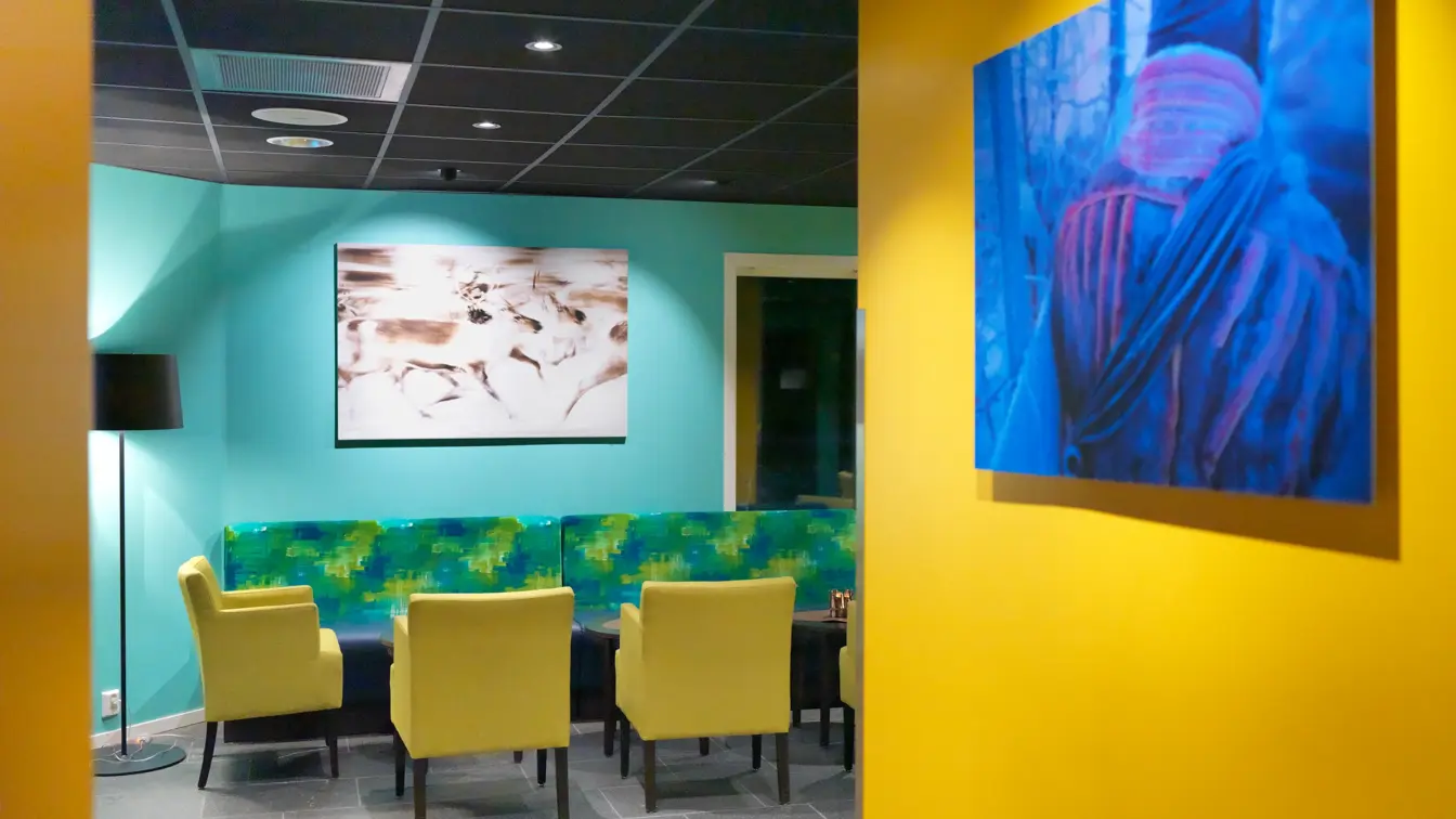 Fargerok lounge på Thon Hotel Kautokeino. Gule og turkise vegger med innslag av grønne og gule møbler.